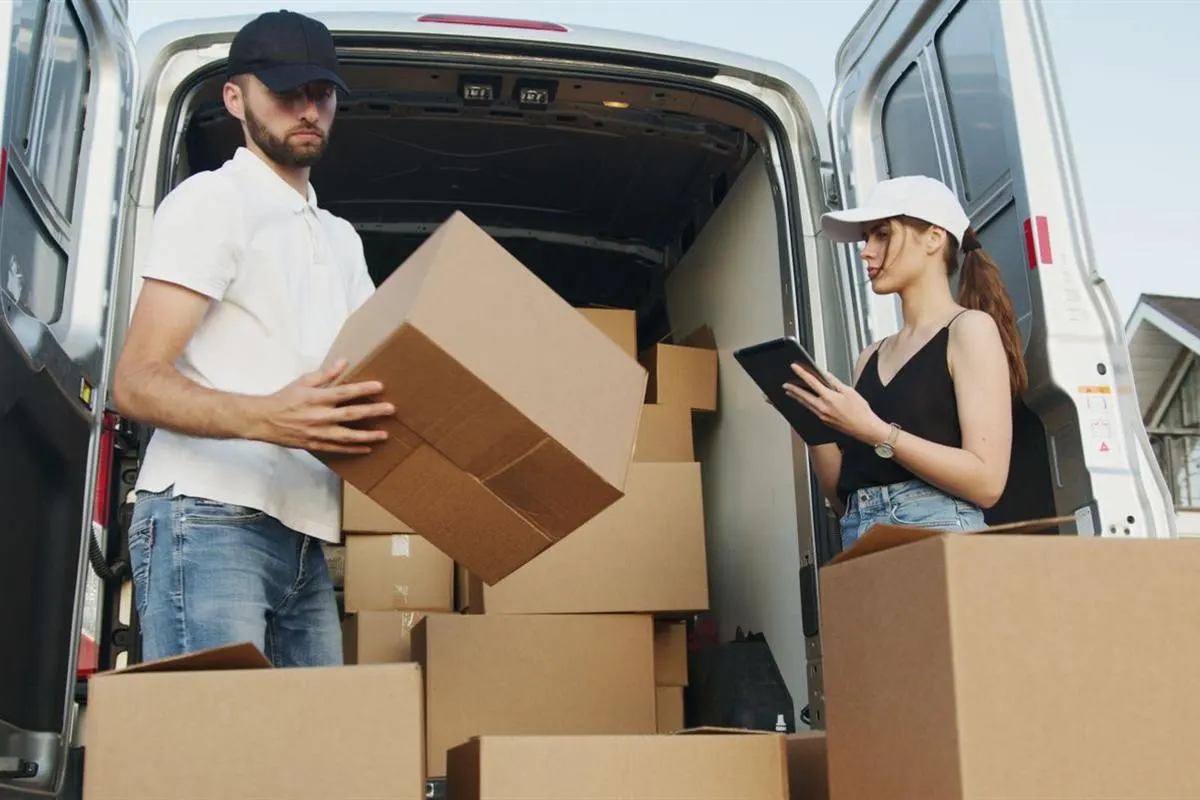 Crew loading labelled household cartons into the moving van